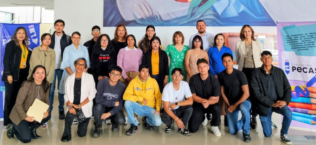 Grupo de becarios y equipo de Fundación Pecas frente a un mural, con las lonas de la Fundación a los lados